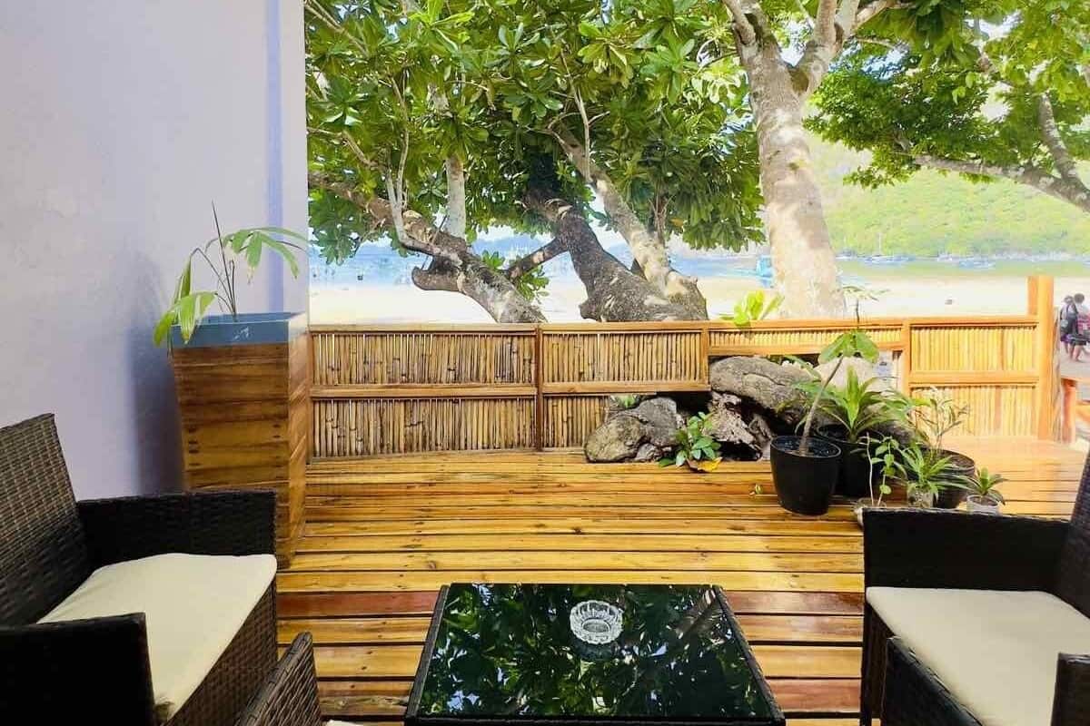 An outdoor seating area with wicker furniture and a view of the beach.