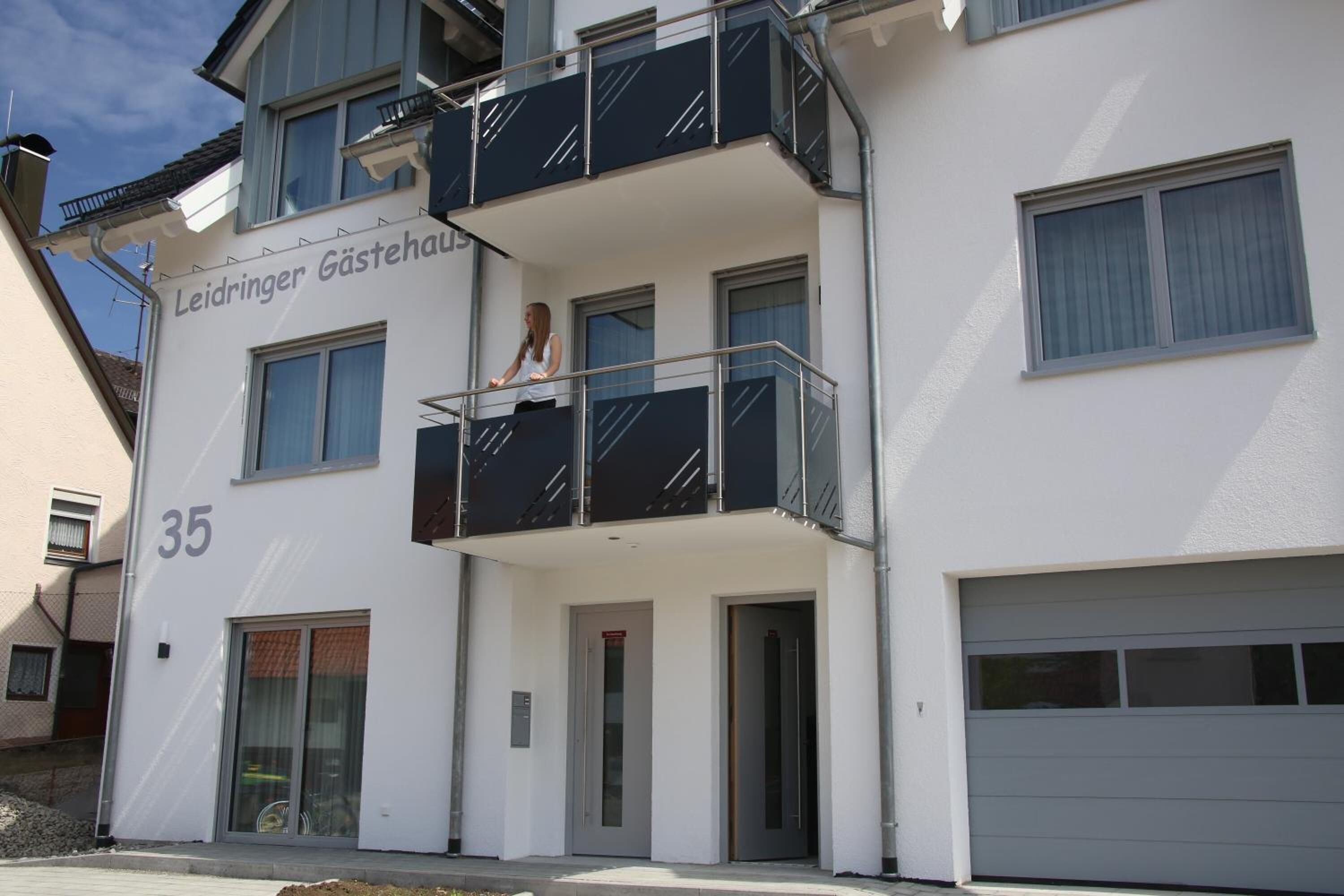 A multi-story building with a balcony and a garage.