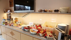 Mostrador de buffet con diferentes alimentos y un tostador.