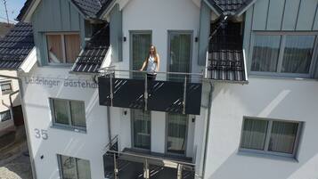 A two-story building with a balcony and solar panels on the roof.