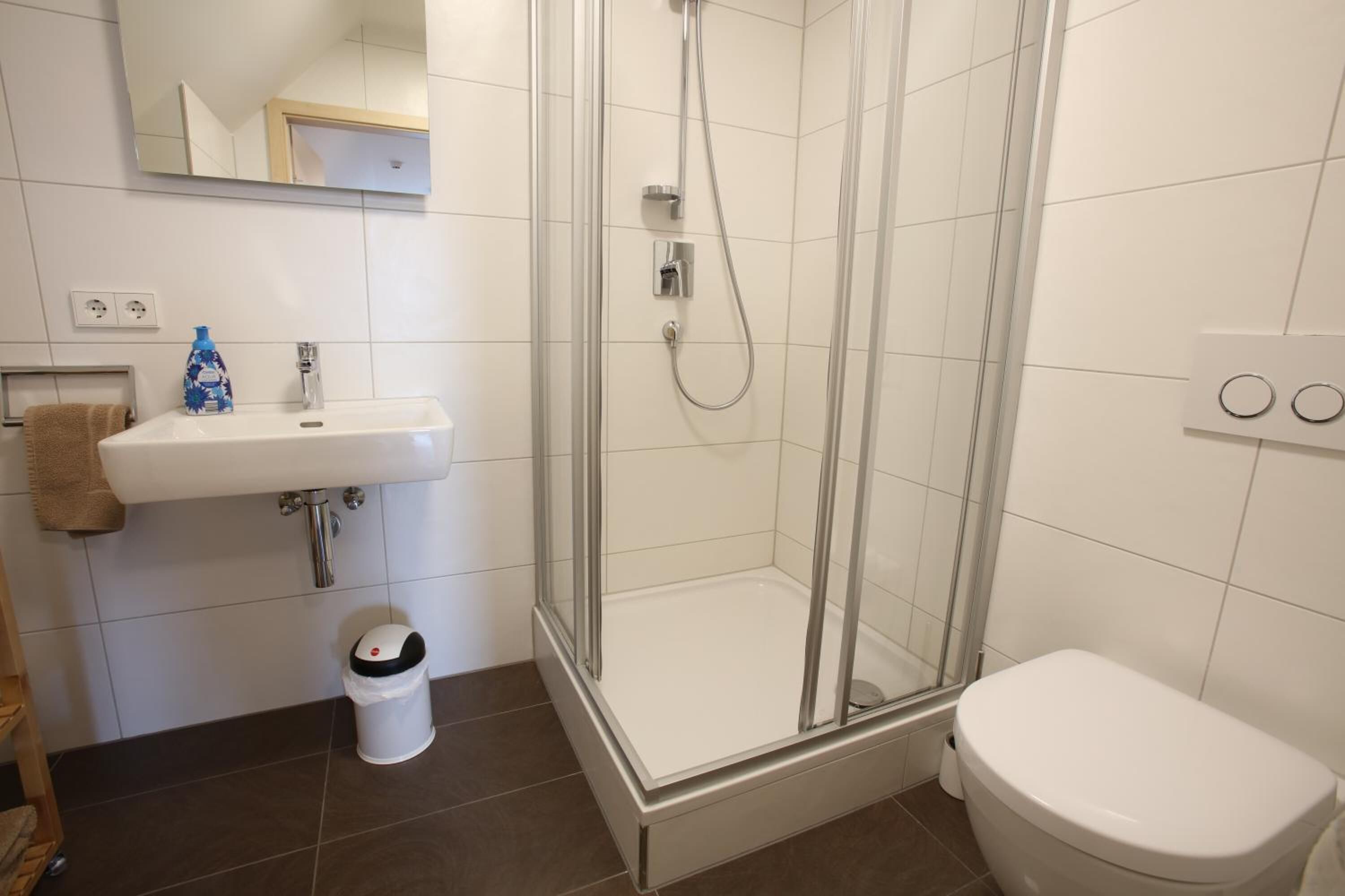 Une salle de bain avec une douche, un lavabo et des toilettes.