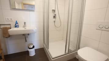 Une salle de bain avec une douche, un lavabo et des toilettes.