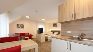 Una cocina moderna con armarios blancos, encimera de madera y pileta de acero inoxidable.