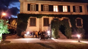 A large two-story building with a covered front porch and a staircase leading to the entrance. - Ancien Presbytère Albert Schweitzer (Gunsbach)