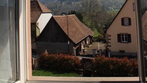 A view from a window overlooking a rural landscape with houses and hills. - Ancien Presbytère Albert Schweitzer (Gunsbach)