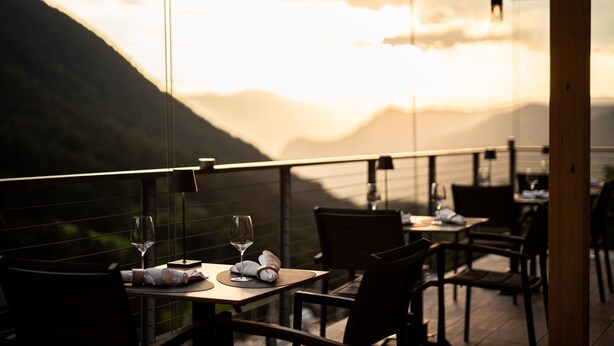 Un restaurante con mesas dispuestas para comer, con vistas a un paisaje montañoso.