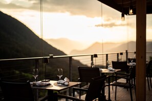 A restaurant with tables set for dining, overlooking a mountainous landscape. - Hotel Berghang (Cornedo All'isarco)