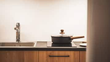 Une cuisine équipée d’un évier en acier inoxydable, d’une cuisinière et de meubles de rangement en bois.