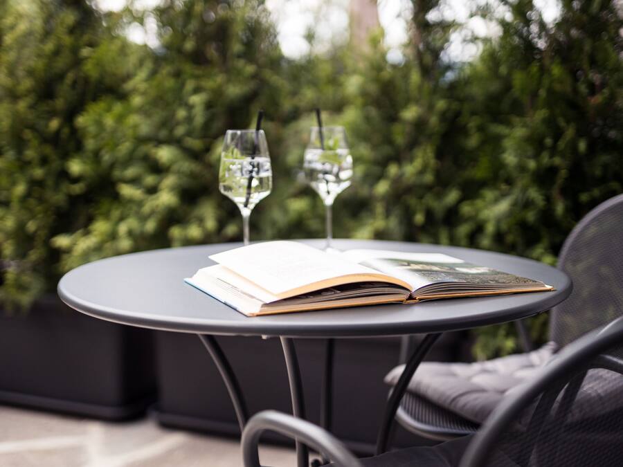 A round table with two wine glasses and an open book.