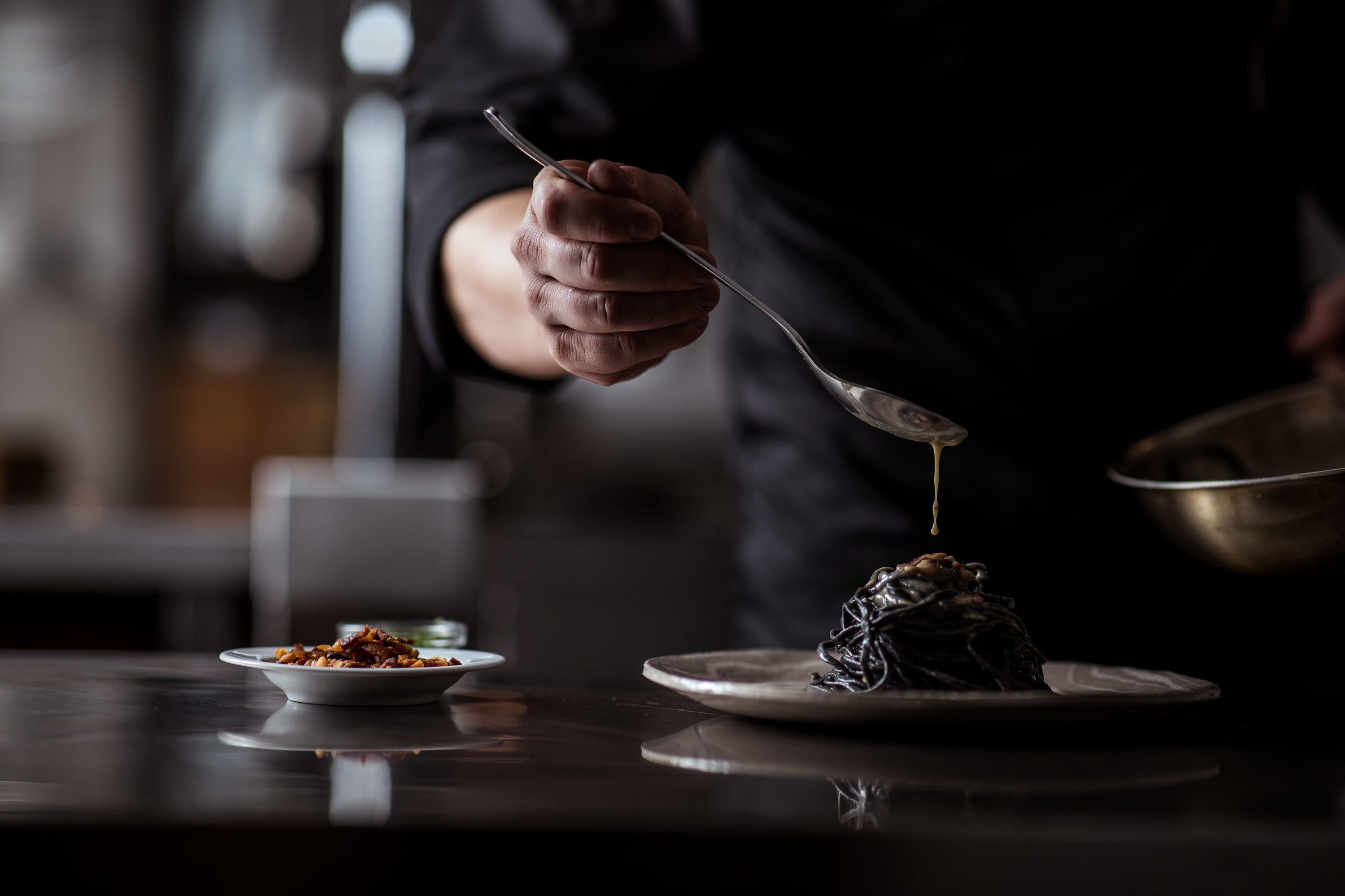 A person serving food from a bowl onto a plate.