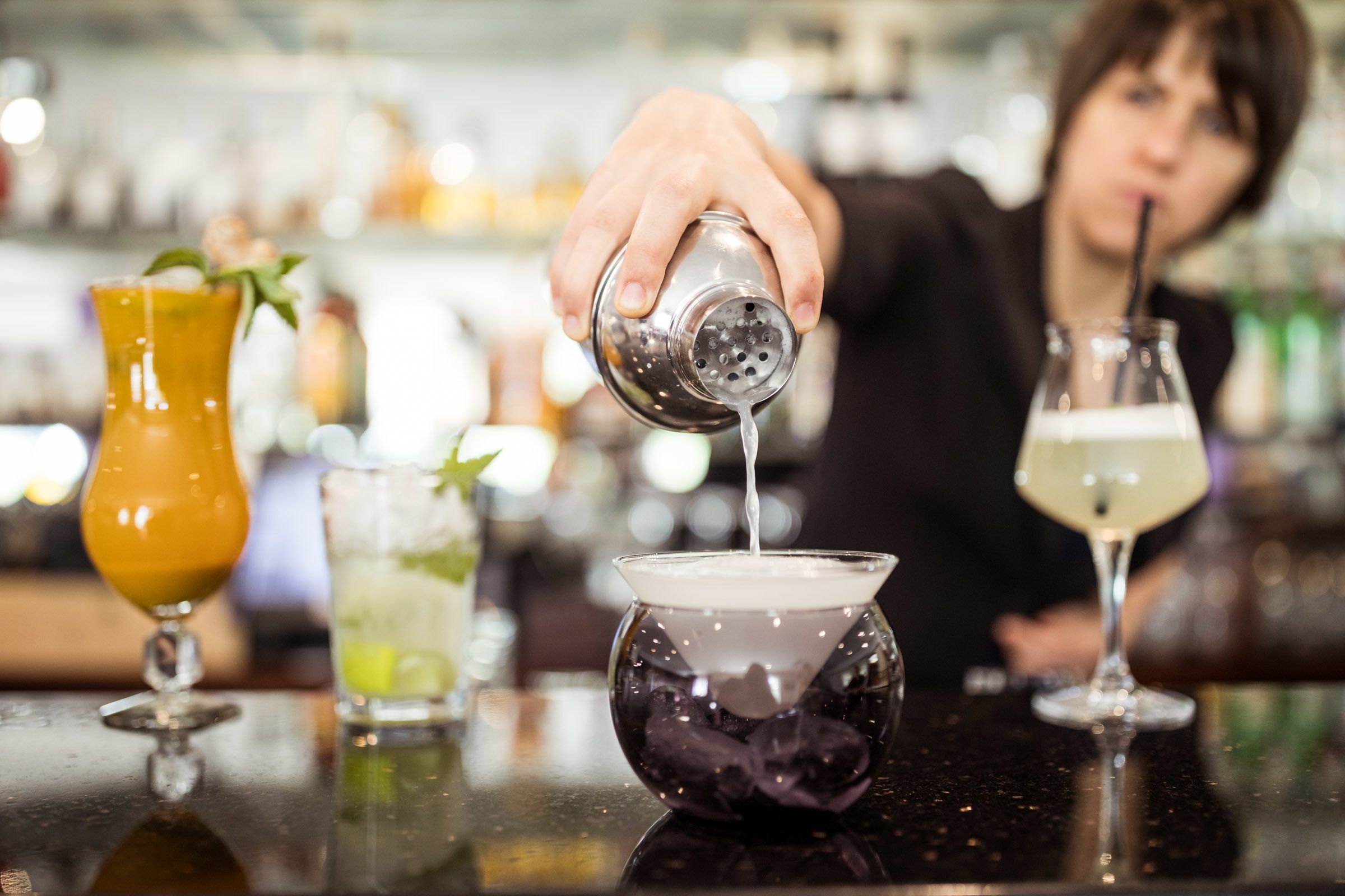 Een bartender schenkt een drankje in.