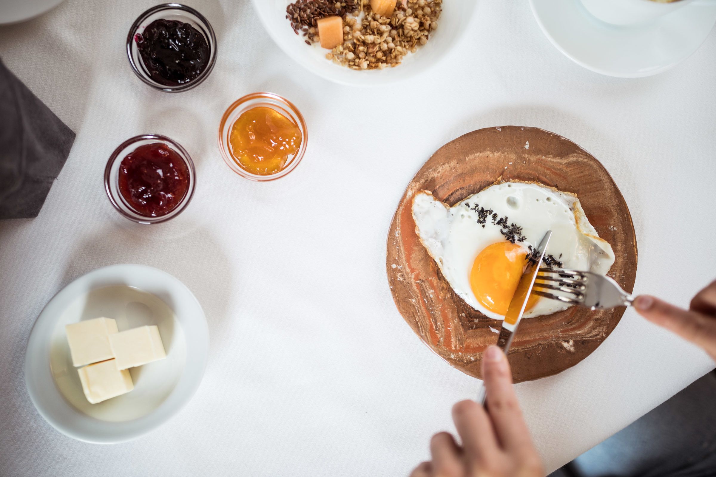 Un desayuno con huevos, tostadas y mermelada.