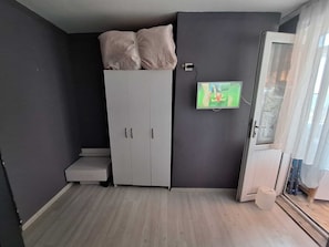 A room with a wardrobe, a television, and a door with a view. - Dilmac Hotel (Gallipoli)