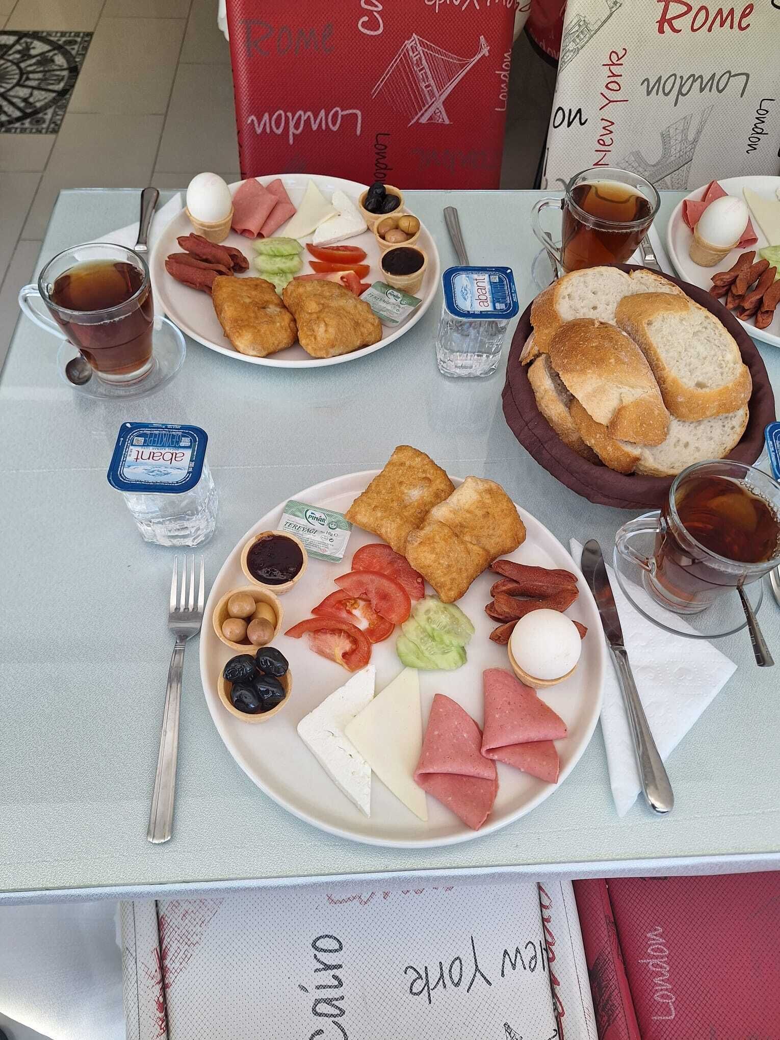 Una mesa de desayuno con platos de comida, bebidas y salsas.