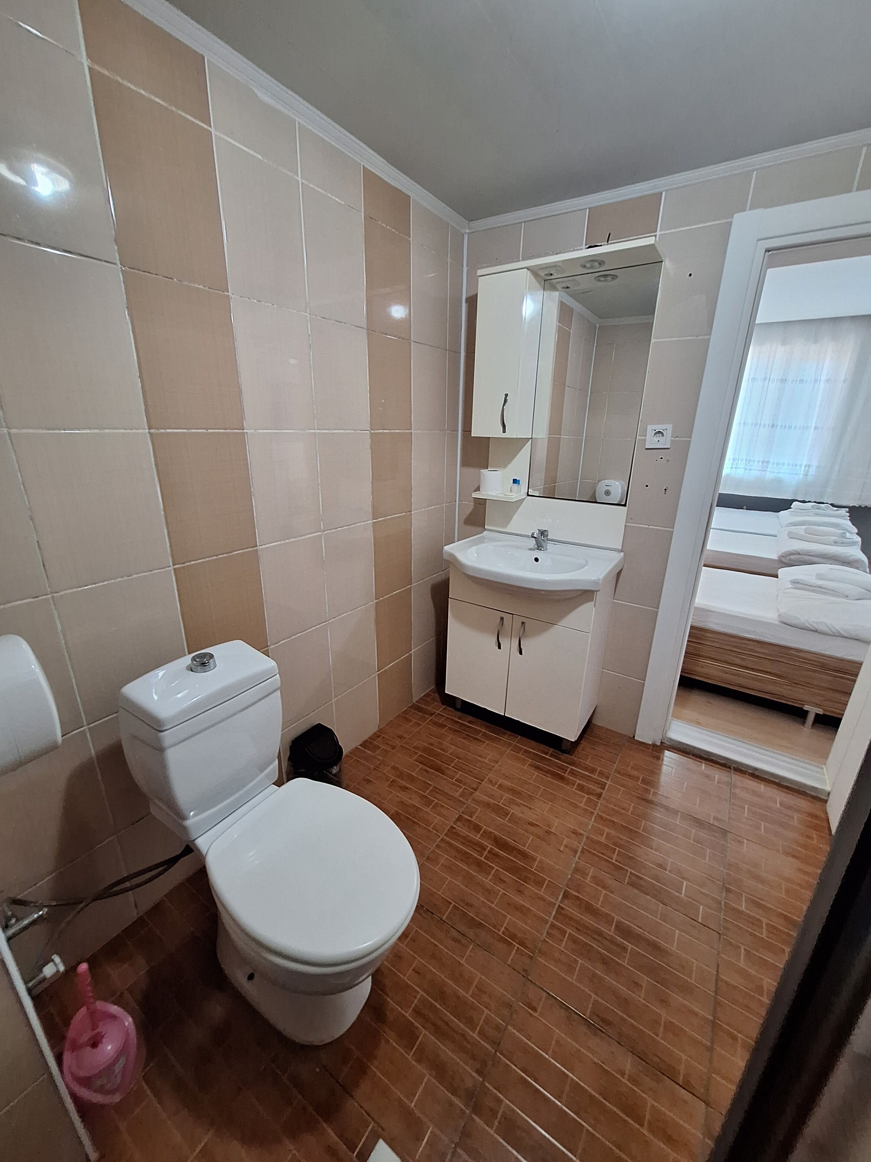 Un baño con inodoro, lavamanos y espejo.