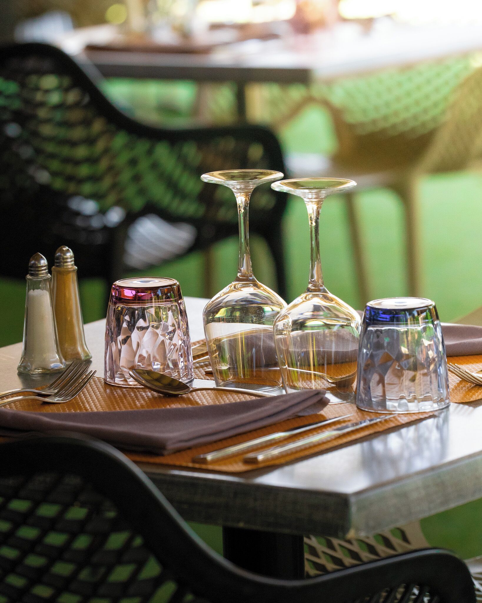 A table set with clear glassware, a salt and pepper shaker, and a spoon.