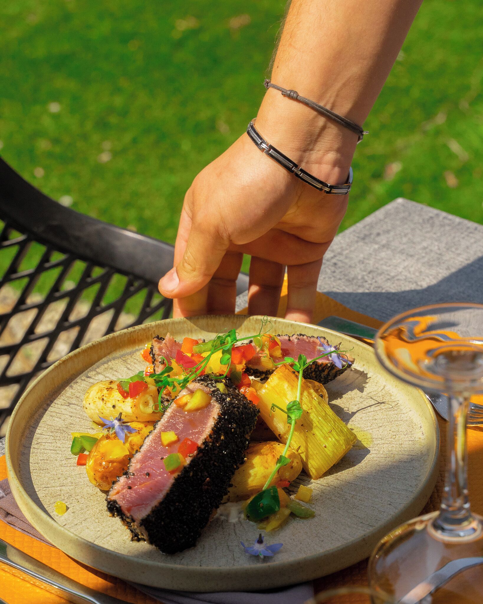 A plate of food with a variety of vegetables and a slice of meat, served on a ceramic plate.