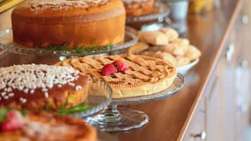 A buffet table with various baked goods including cakes and pastries.