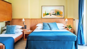 Une chambre d’hôtel avec deux lits, un tableau au mur et une fenêtre avec des rideaux.