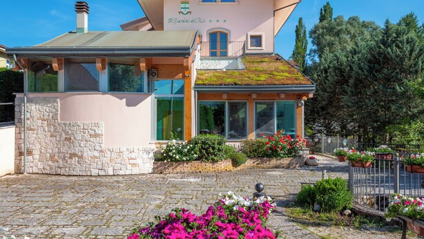 Un bâtiment rose sur lequel on peut lire l’inscription « Il Giardino del Rio ».
