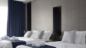 A hotel room with two beds, a large window with curtains, and a modern design. - The District Hotel (St. Julian's)