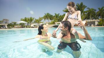 Relax by the pool surrounded by palm trees and lush landscaping.