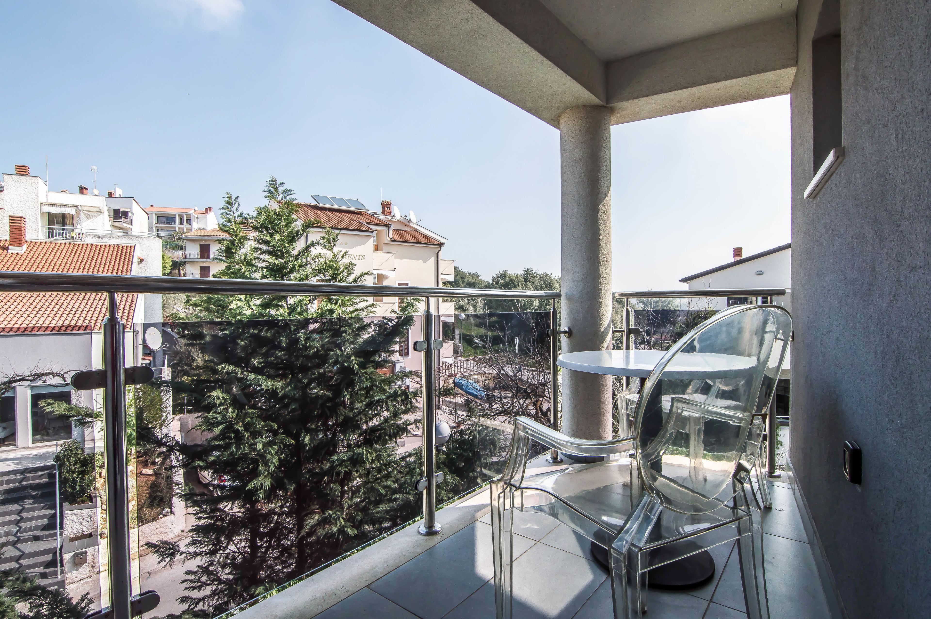 Un balcon offrant une vue dégagée sur les bâtiments et les arbres environnants.