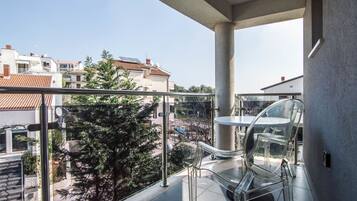 Un balcon offrant une vue dégagée sur les bâtiments et les arbres environnants.