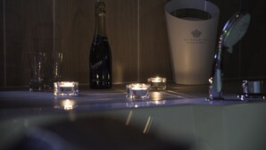 A bottle of champagne, two glasses, and a bucket with a logo on a wooden surface. - Il Centro Short Lets (Valguarnera Caropepe)