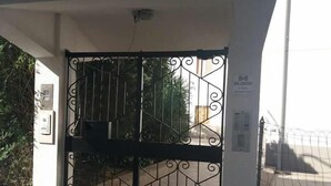 A gated entrance with a metal gate featuring geometric patterns. - Il Centro Short Lets (Valguarnera Caropepe)
