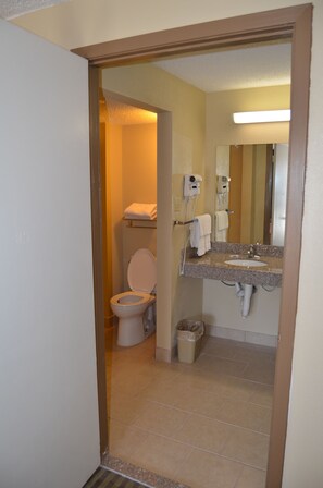 Un baño con inodoro, lavabo y espejo.