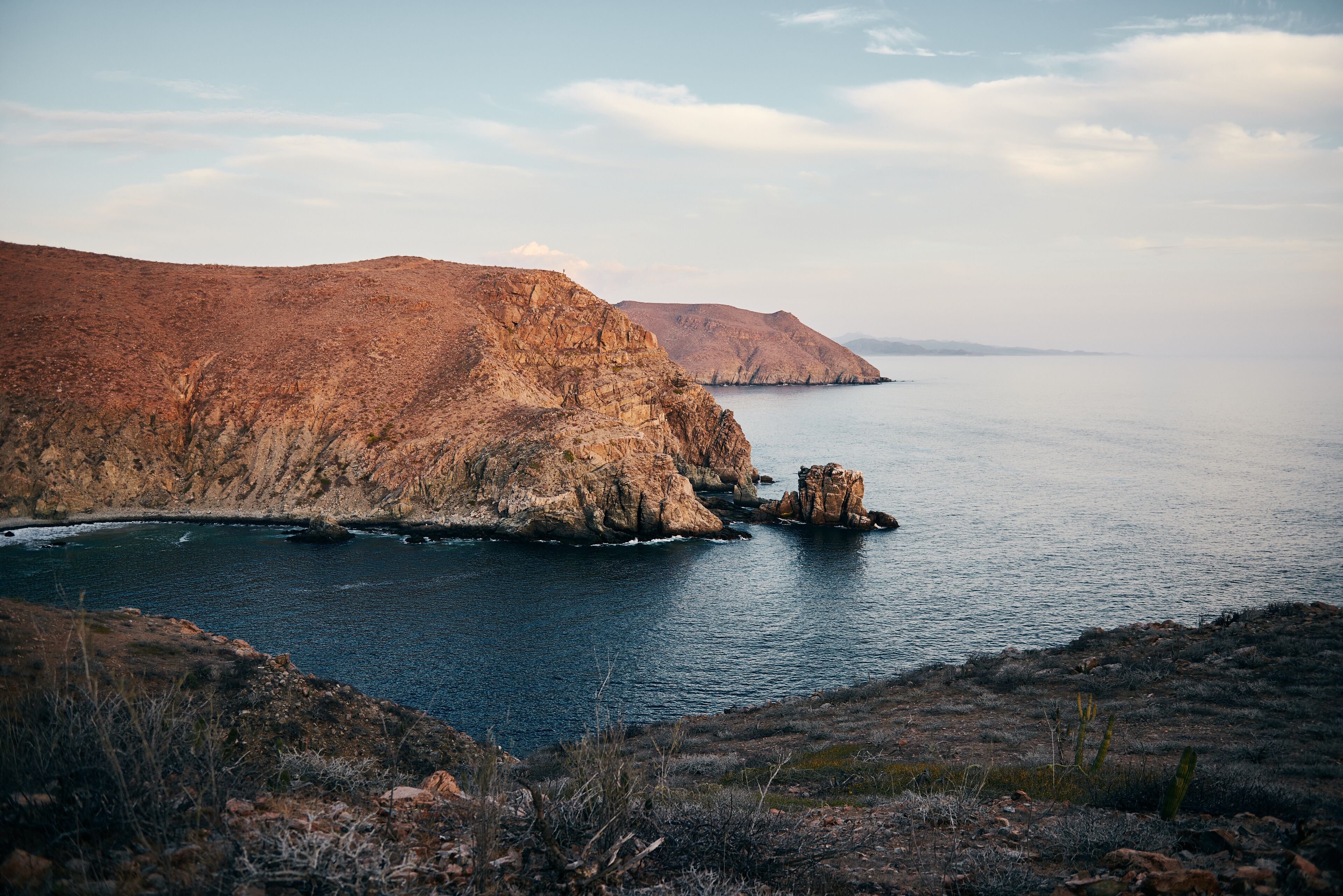 Un paisaje costero con acantilados rocosos y un mar tranquilo.