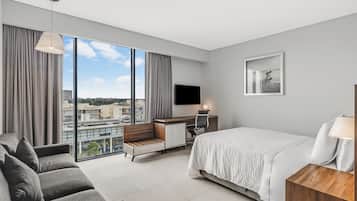Een moderne hotelkamer met een groot bed, een bureau, een stoel, een bank en een televisie.