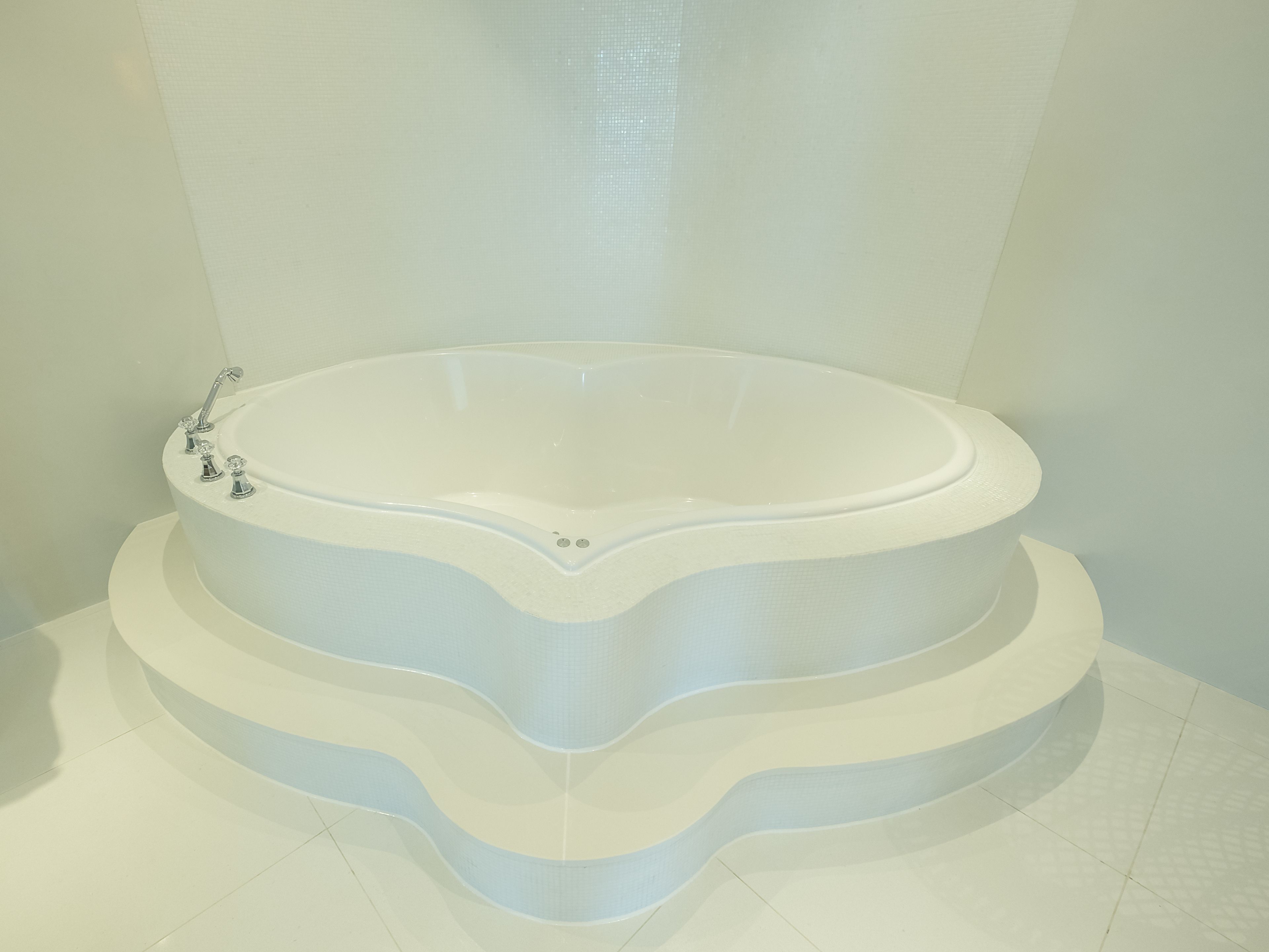 A large, freestanding bathtub with a unique, wavy design.