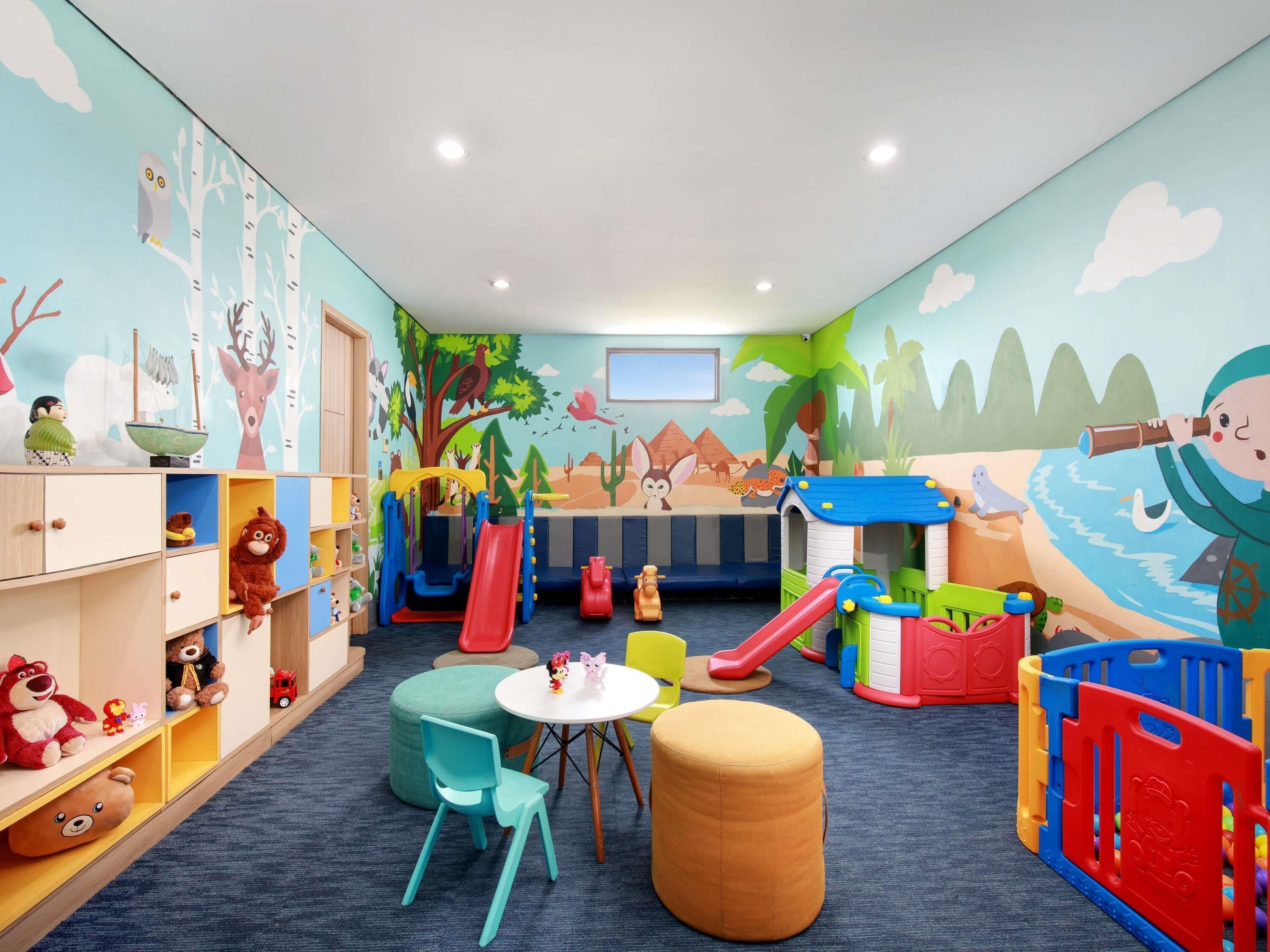 Een kinderspeelkamer met een glijbaan, een speelhuisje en diverse speelgoed.