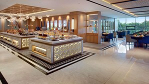 Recepció d'hotel moderna amb barra de buffet central, zona de seients i grans finestres que ofereixen vistes a l'exterior.