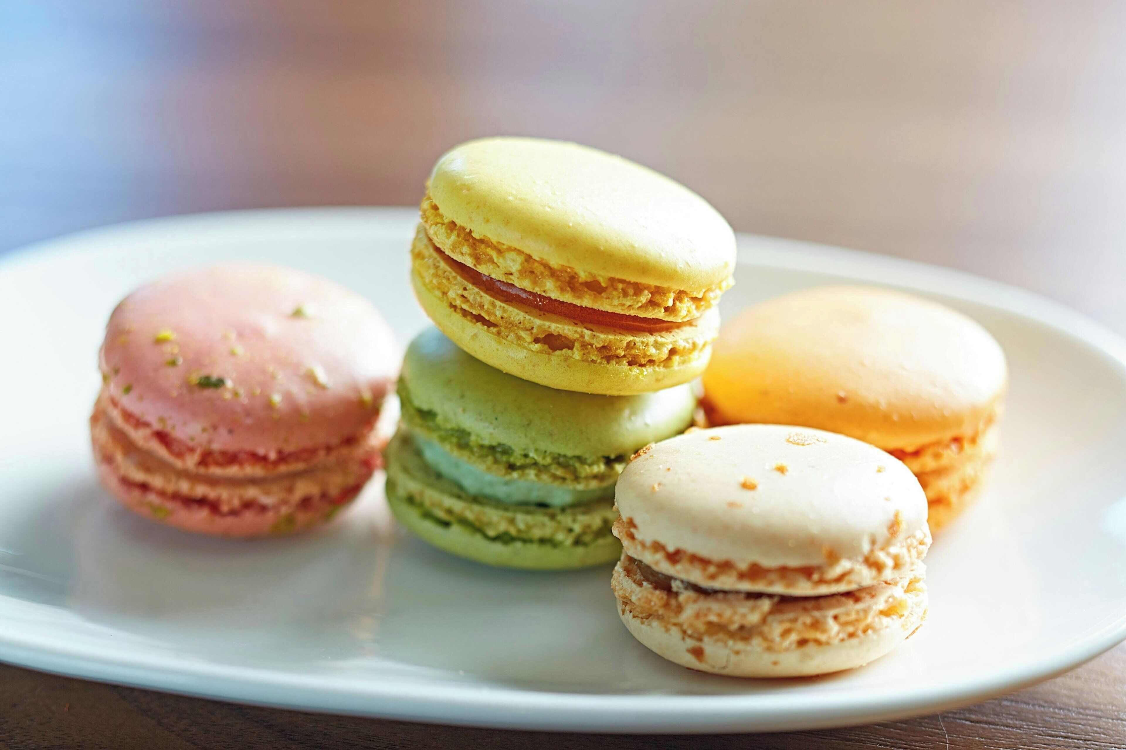 Un plato de macarons de colores sobre un plato blanco.