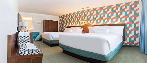 A hotel room with two beds, a wooden bench, and a patterned wall.