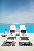 Una piscina al aire libre, sillones reclinables de piscina