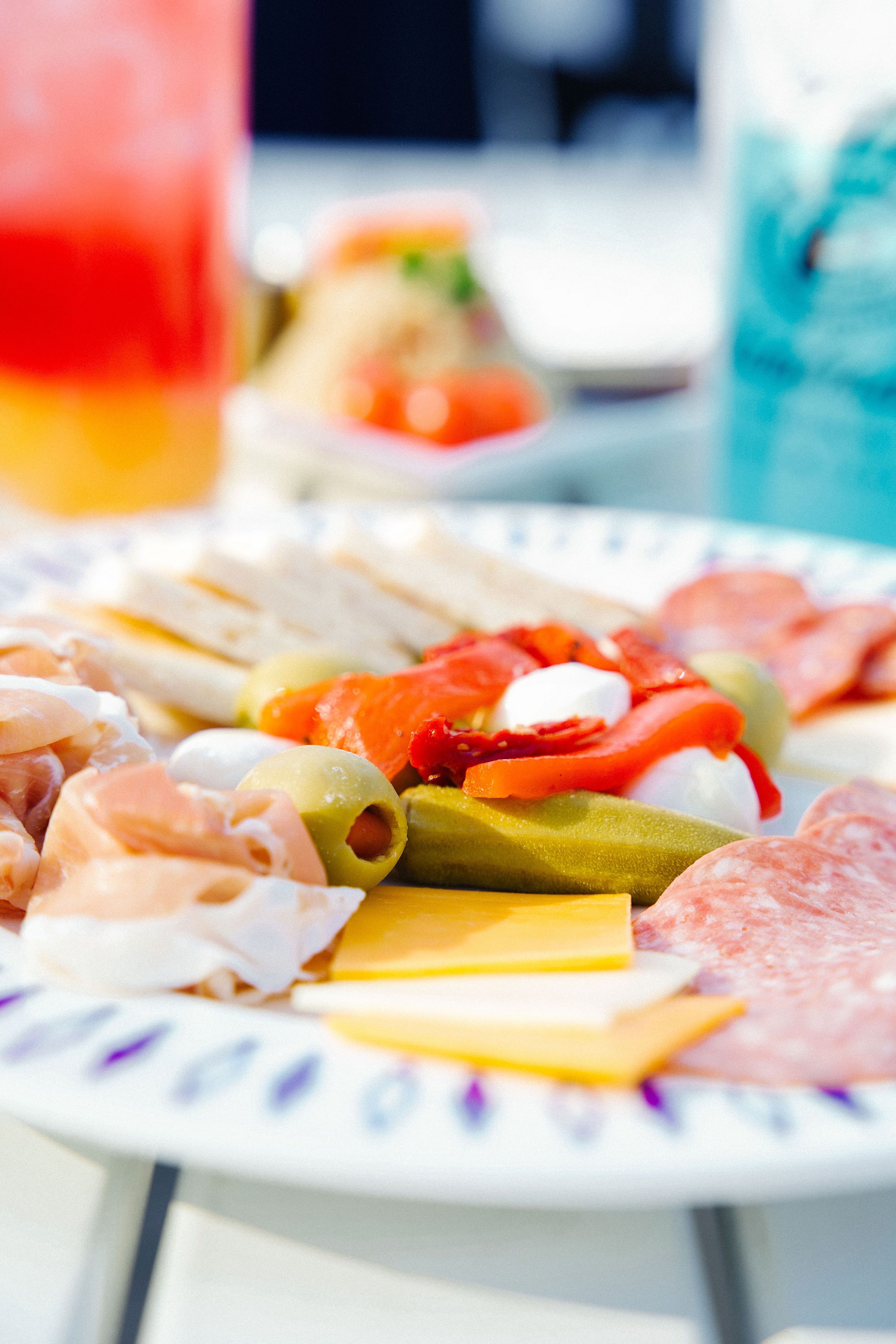 A plate of assorted cheeses, cured meats, and olives.