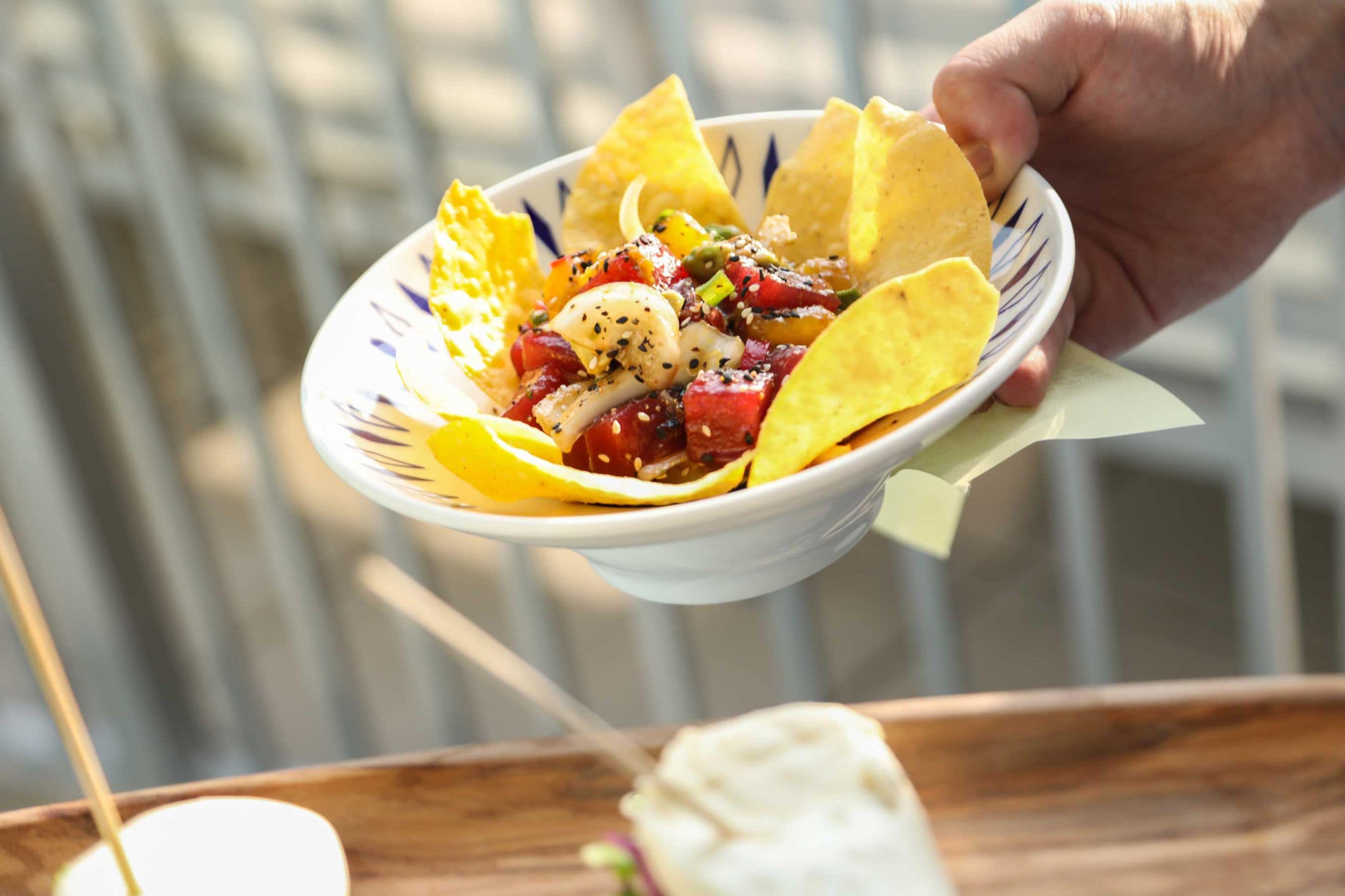 Eine Schüssel Nachos mit verschiedenen Belägen und Chips.