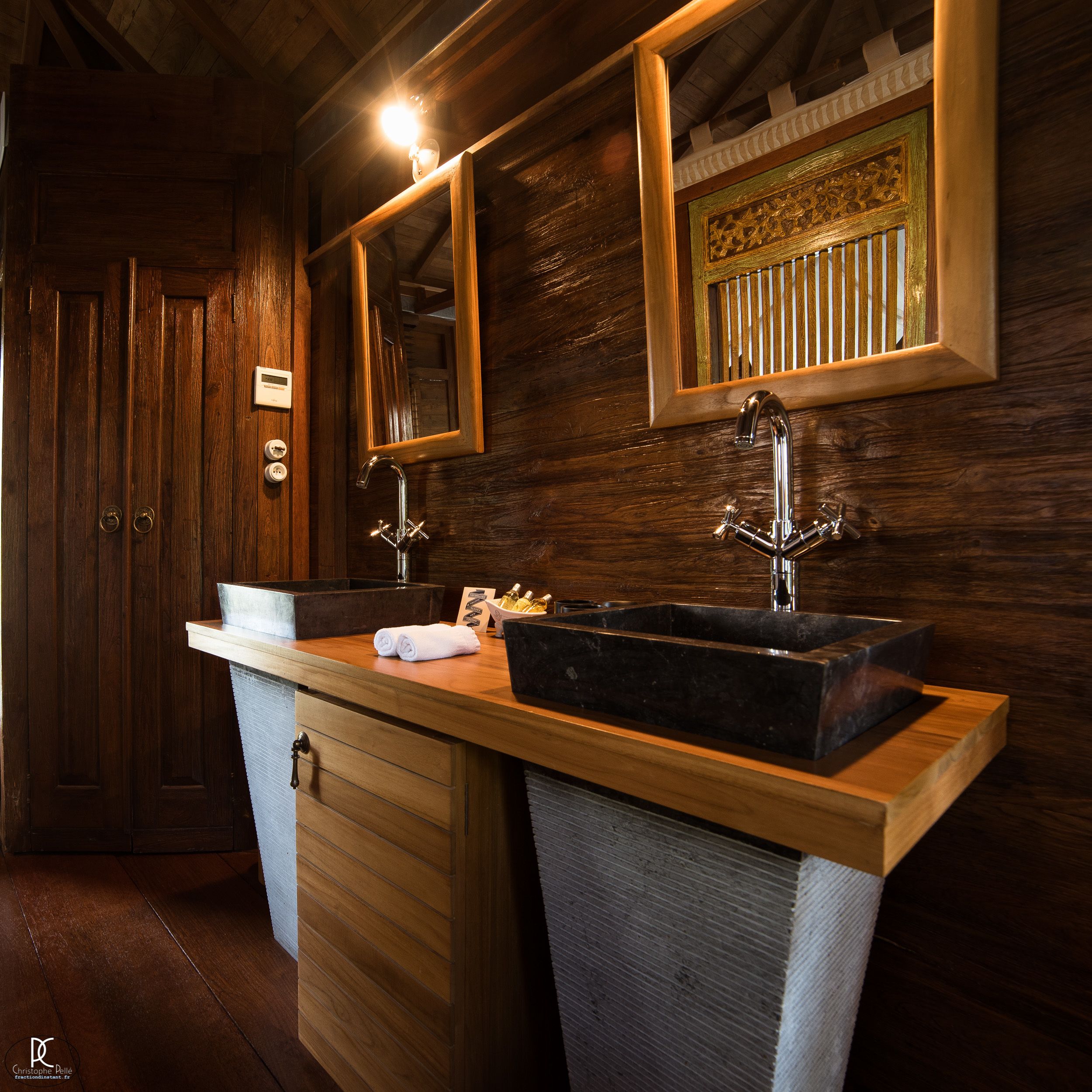 Un baño de madera con un espejo grande, un lavabo y un perchero para toallas.