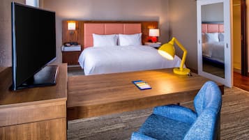 Habitación de hotel con cama, lámparas de noche, escritorio con una computadora portátil y una silla.