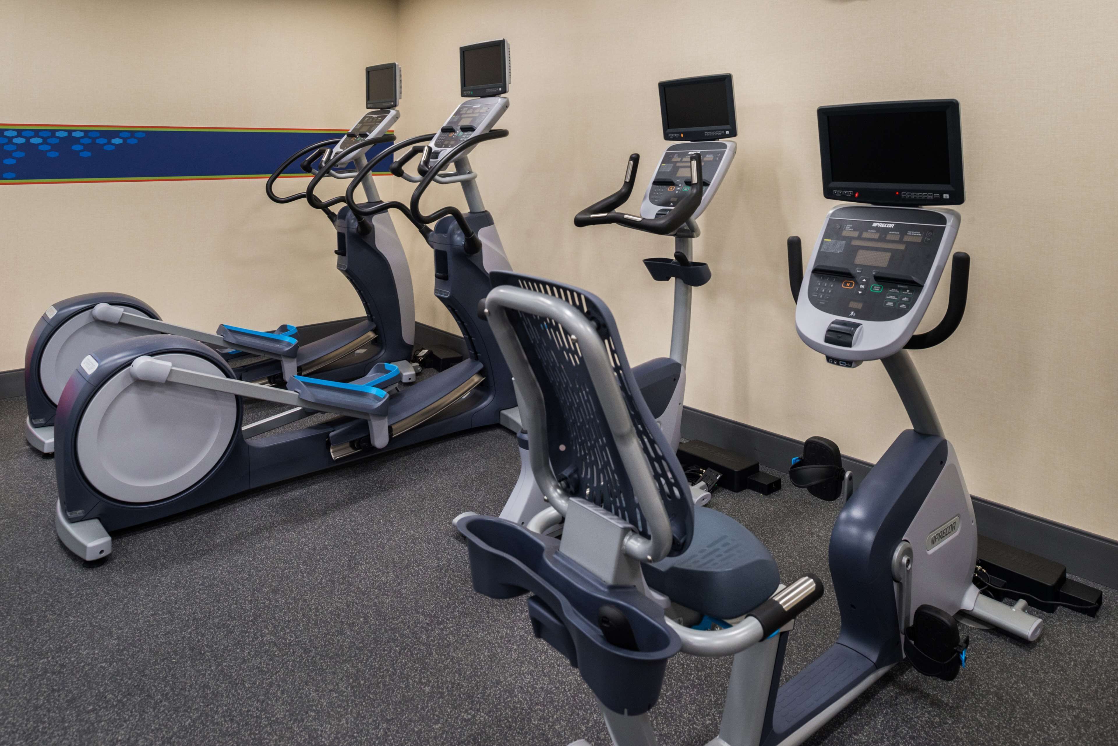Una palestra con tapis roulant, cyclette e macchinari ellittici.