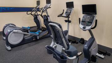 Una palestra con tapis roulant, cyclette e macchinari ellittici.