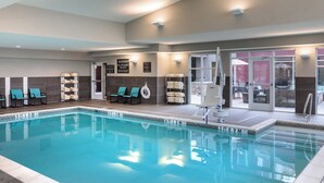 An indoor swimming pool with lounge chairs, a lifeguard chair, and a view of the outside patio area. - Residence Inn by Marriott Dallas Plano/Richardson at Coit Rd (Plano)