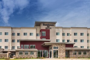 A multi-story hotel with a maroon and beige facade, large windows, and a prominent entrance. - Residence Inn by Marriott Dallas Plano/Richardson at Coit Rd (Plano)