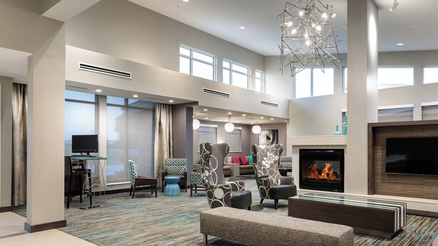 A spacious hotel lobby with a high ceiling, large windows, a fireplace, and modern furniture. - Residence Inn by Marriott Dallas Plano/Richardson at Coit Rd (Plano)