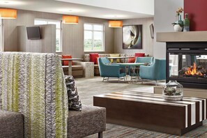 A modern hotel lobby with a seating area, a fireplace, and large windows. - Residence Inn by Marriott Dallas Plano/Richardson at Coit Rd (Plano)