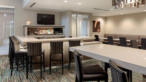 A modern hotel lobby with a bar area, seating, and a television. - Residence Inn by Marriott Dallas Plano/Richardson at Coit Rd (Plano)